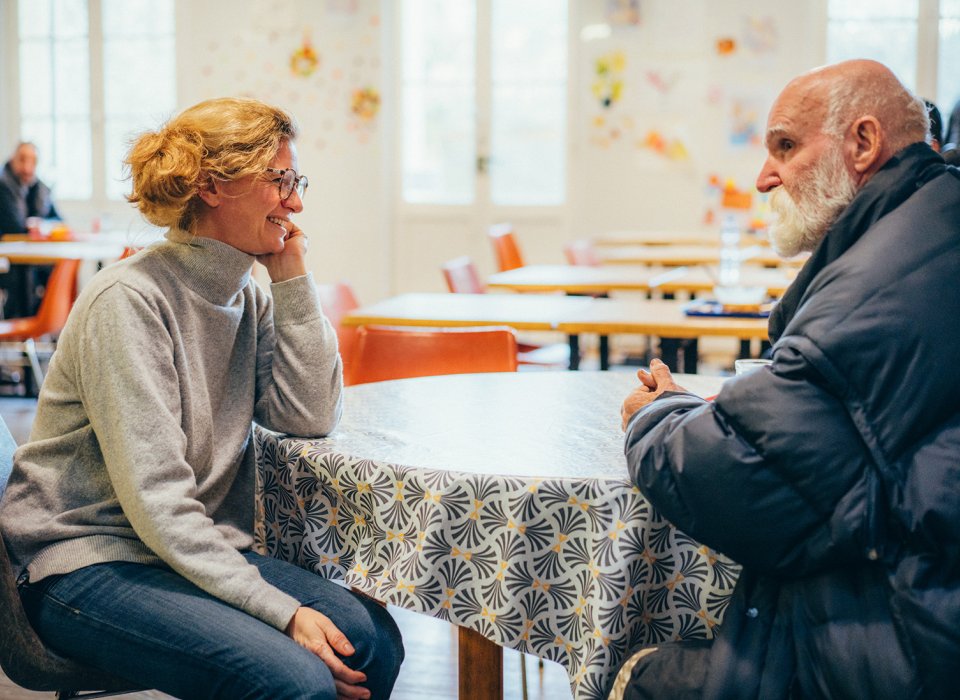 une bénévole et un accueilli discutent à la Halte du Secours Catholique de Bordeaux